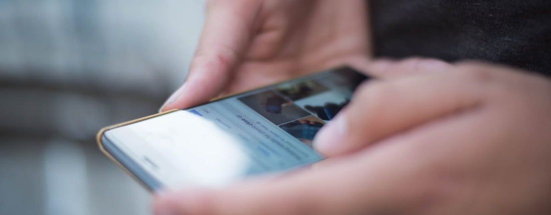 Close-up of hands using a smartphone with a touchscreen, emphasizing mobile technology.