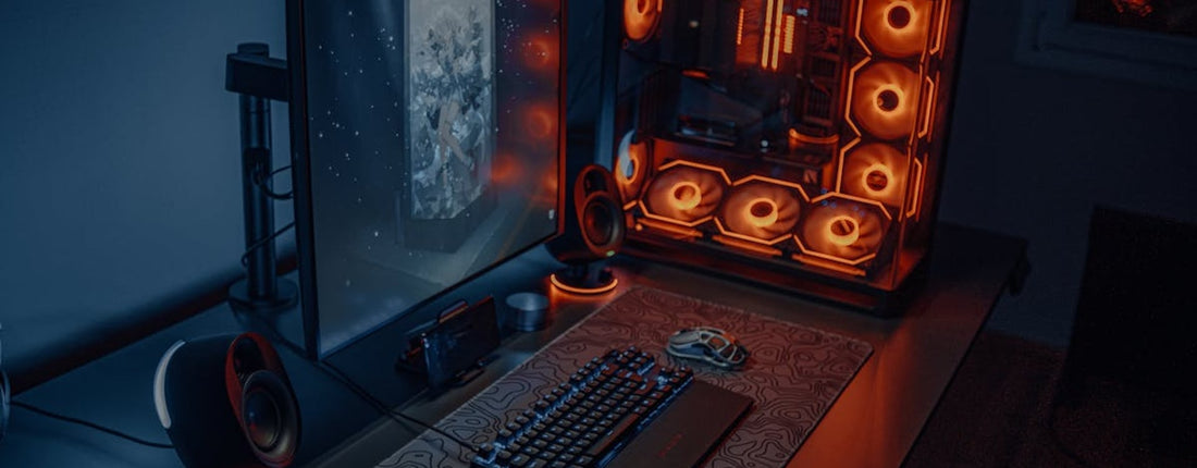 Sleek gaming desk setup featuring RGB lighting, large monitor, and gaming PC with glowing fans.