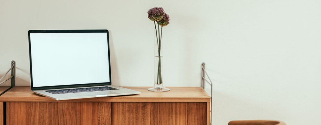 A person focused on their laptop in a modern home office, highlighting the need for effective laptop cooling during extended use.