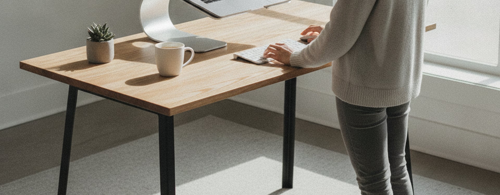A laptop on a sleek cooling laptop stand at a modern standing desk, emphasizing ergonomic posture and efficient heat management.