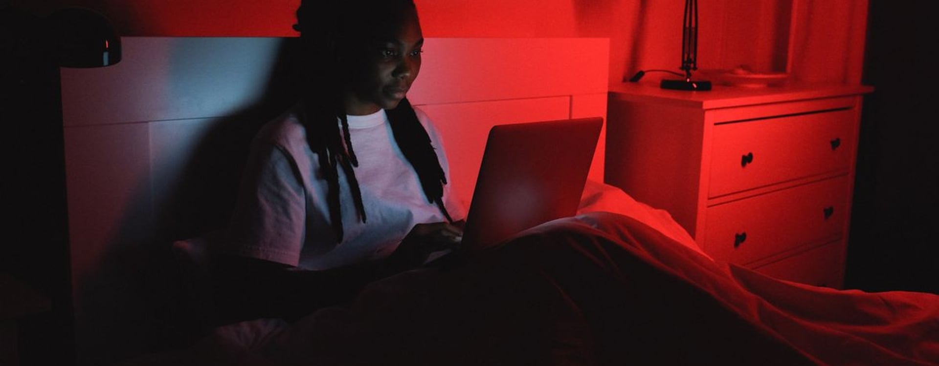 A bedroom music studio with a MacBook Pro on a stand, optimized for quiet and stable audio production with a laptop cooler for MacBook.