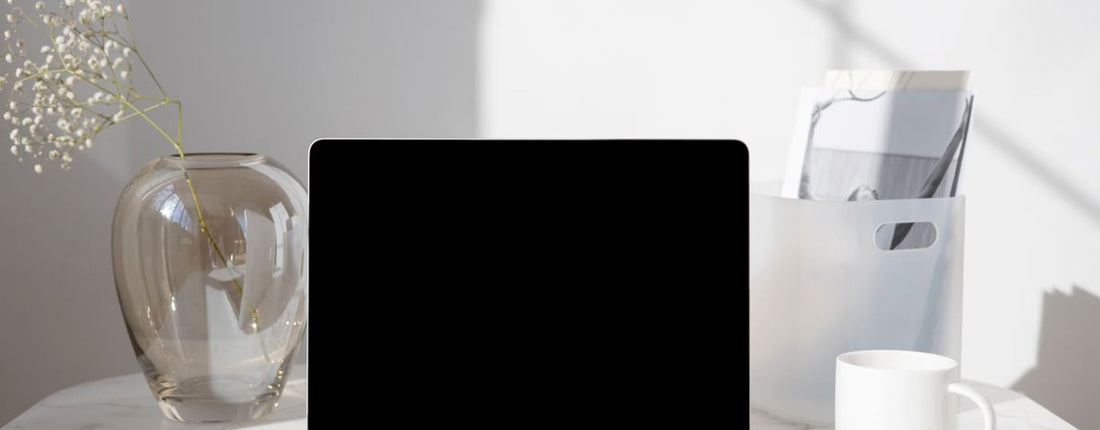 Western MacBook user checking heat in a warm office before choosing an external laptop cooling solution