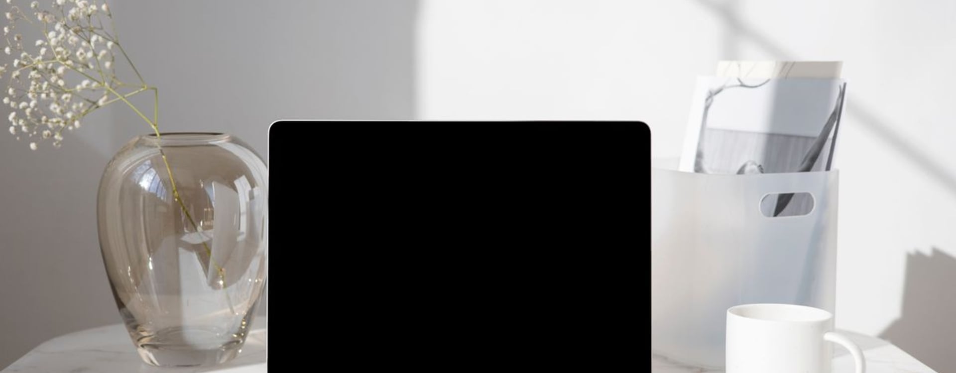 Western MacBook user checking heat in a warm office before choosing an external laptop cooling solution