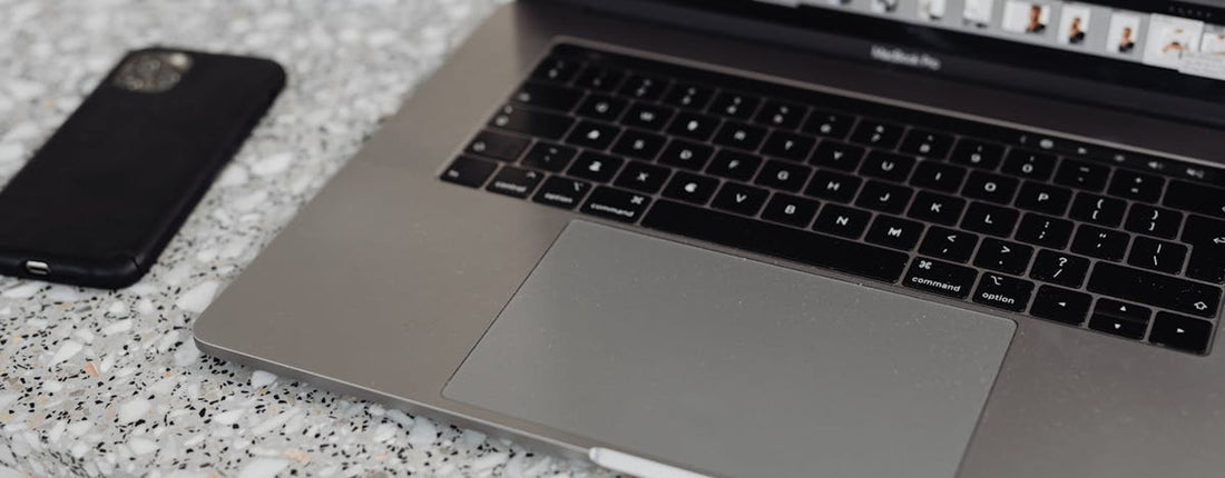 A person intently using a laptop on a desk, highlighting the need for effective laptop cooler solutions during sustained use.