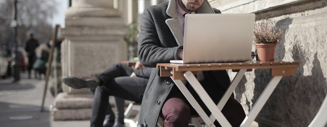 A person working intensely on a laptop at a desk, highlighting the demanding use that can lead to laptop overheating.