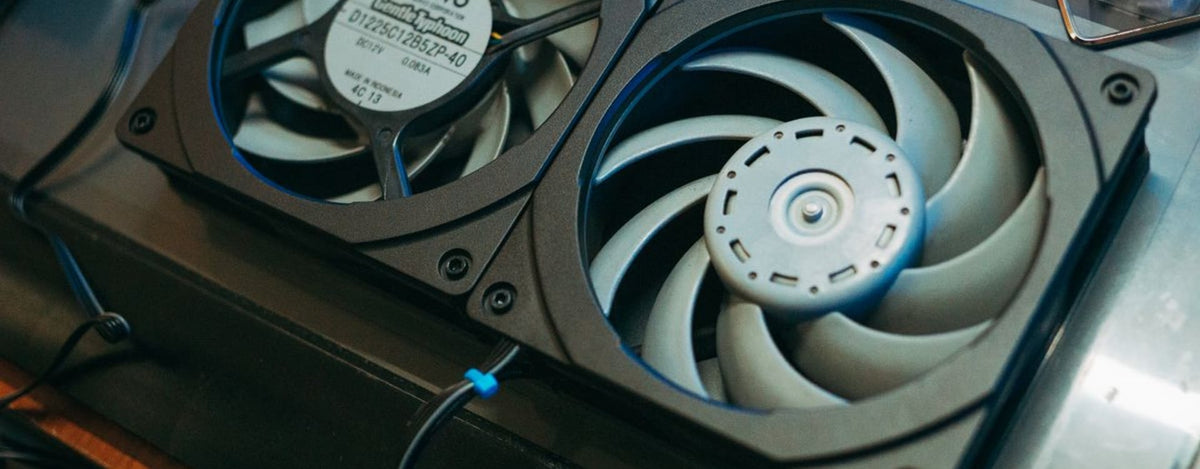 A laptop user experiencing frustration due to a noisy or underperforming laptop cooling fan, indicating thermal issues.