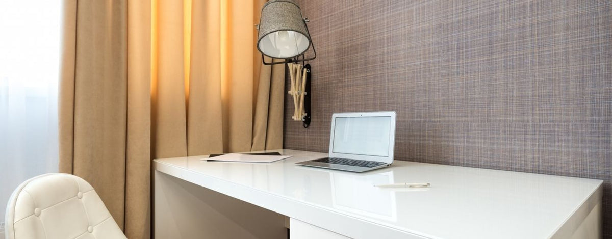 Laptop underside on a desk, showing vents and feet to check before choosing a sealed laptop cooling pad
