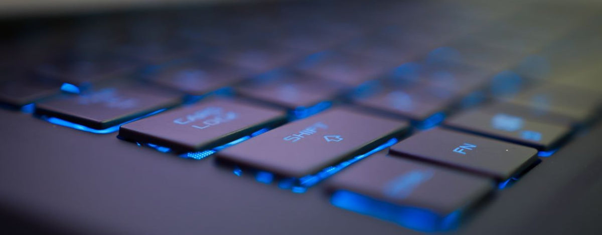 Gamer checks a laptop screen while investigating an FPS cap and possible thermal throttling at a desk